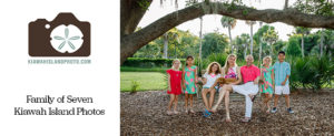 family of seven at park on kiawah island sitting is a swing and around a large oak tree