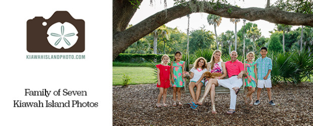 family of seven at park on kiawah island sitting is a swing and around a large oak tree
