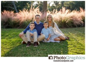 family of four sitting on the grass in a park on kiawah island, kiawah island family photos